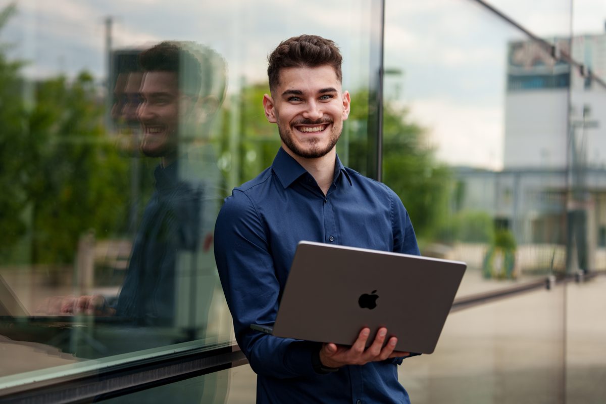 Moritz Benner mit Laptop vor Ort beim Kunden